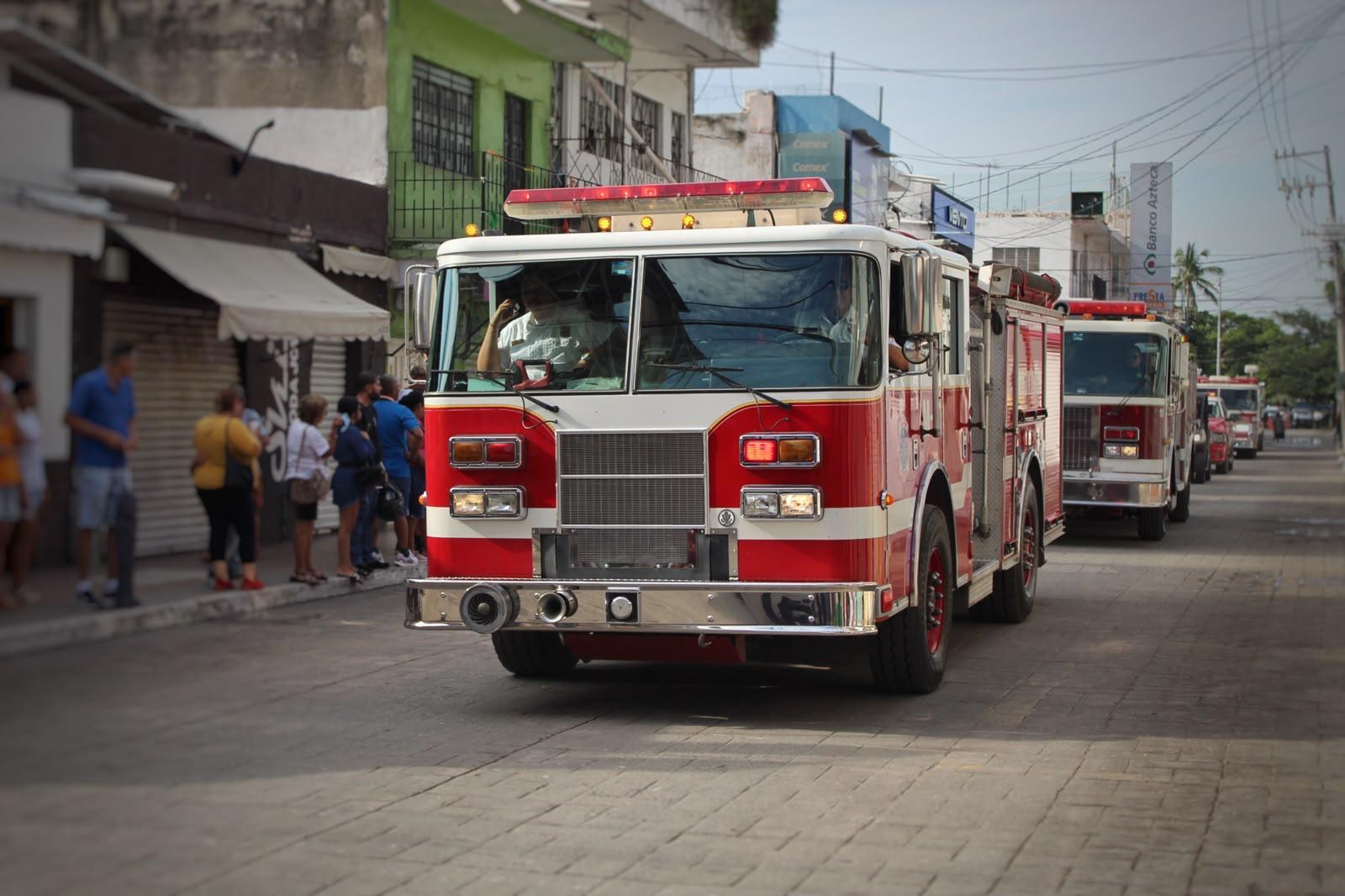 Unidades de emergencia de Bomberos Voluntarios de Manzanillo recorriendo la ruta del desfile